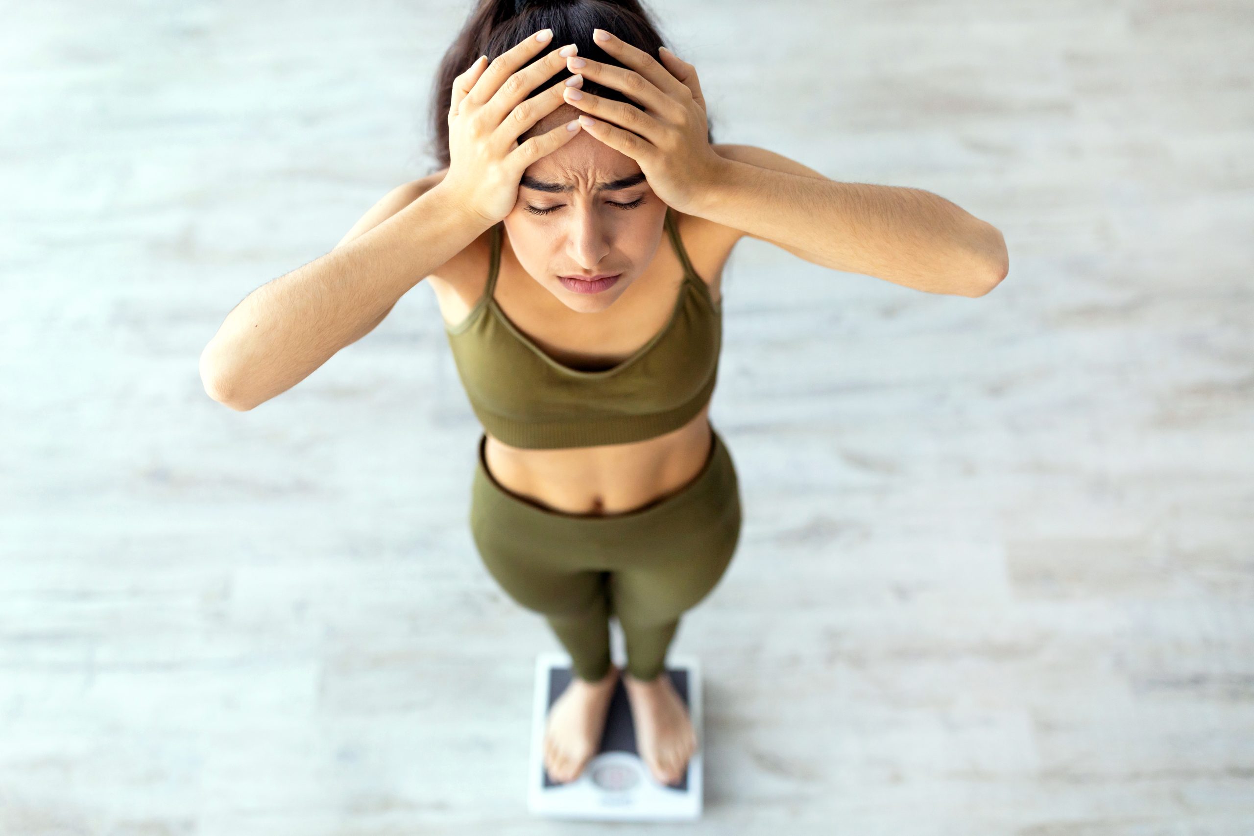 TDEE Calculator woman frustrated for not hitting her fitness goals